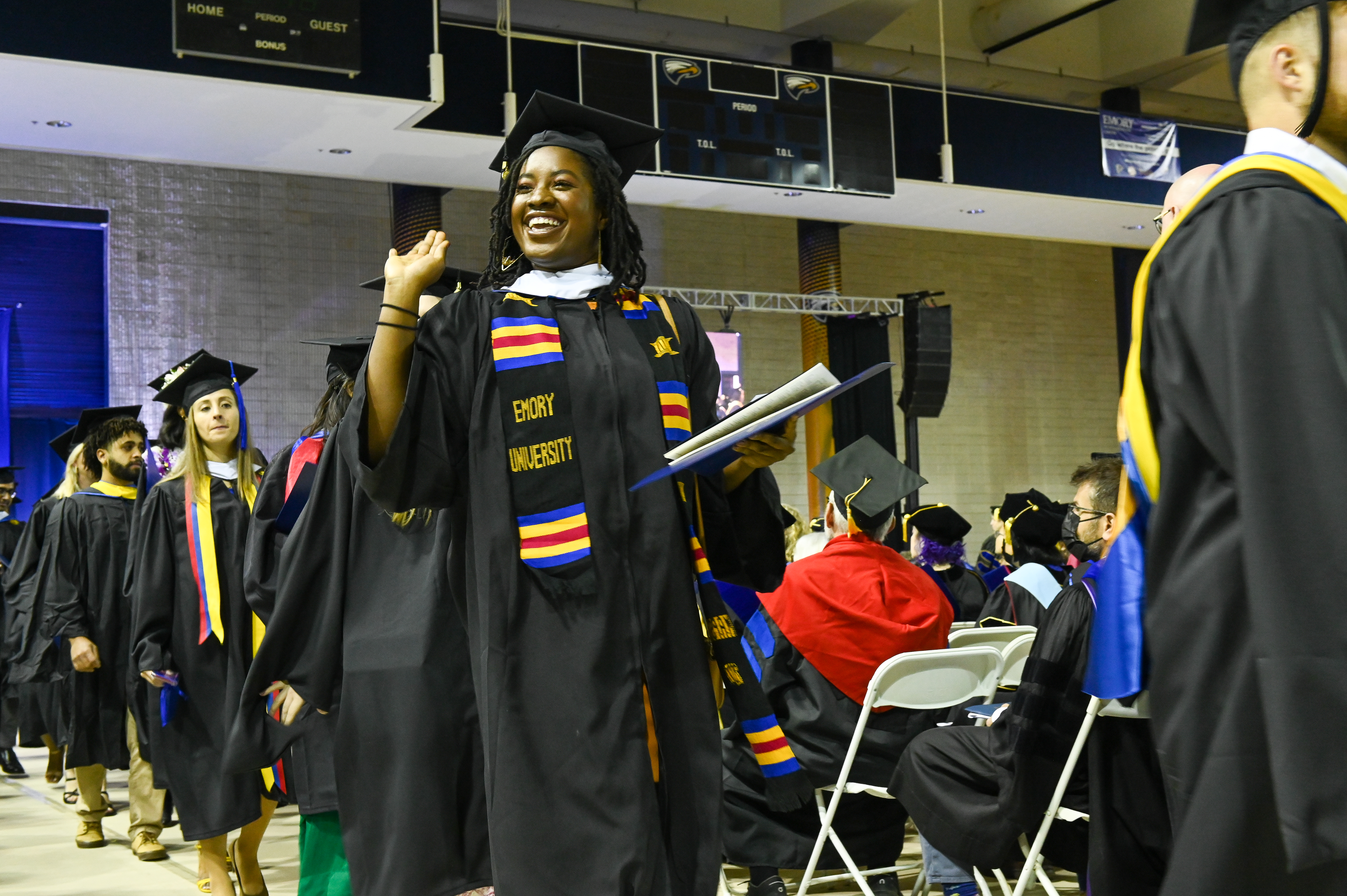 graduate walking and waving